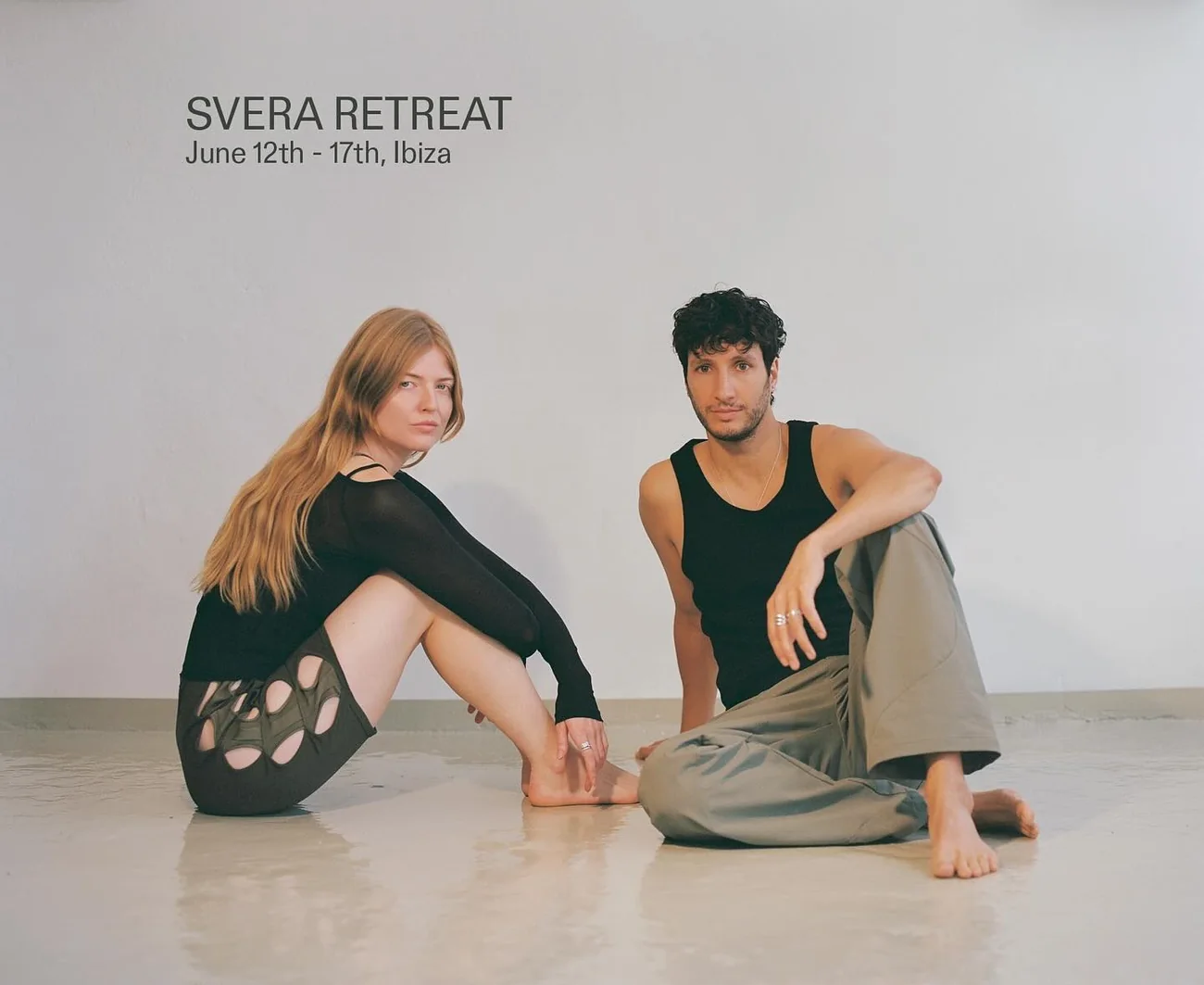 SVERA Retreat campaign image: two figures seated on a studio floor, title set on the bare wall above them